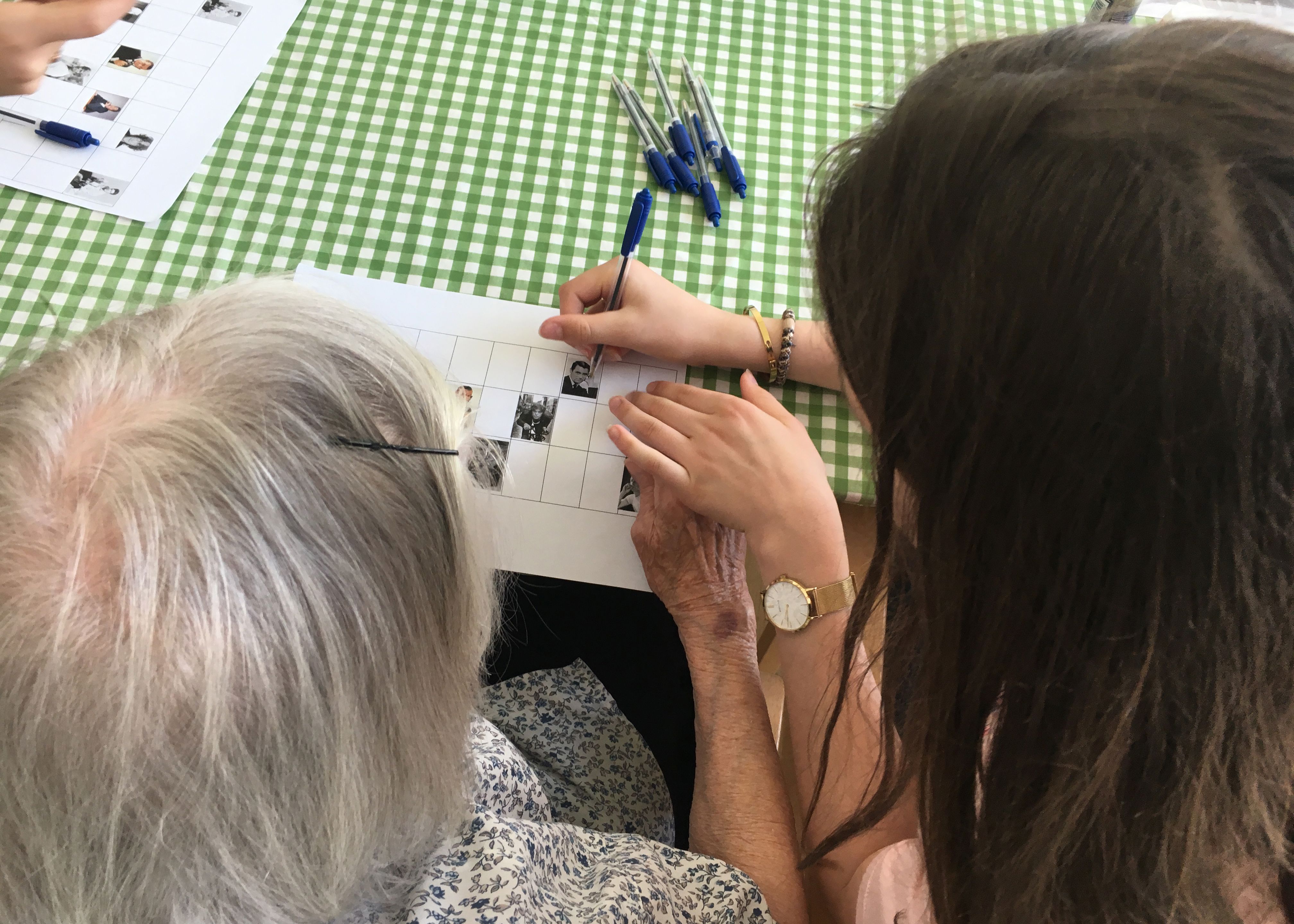 En medarbejder hjælper en beboer med at spille banko.