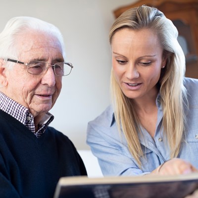 Ældre mand kigger på billeder med sit barnebarn.